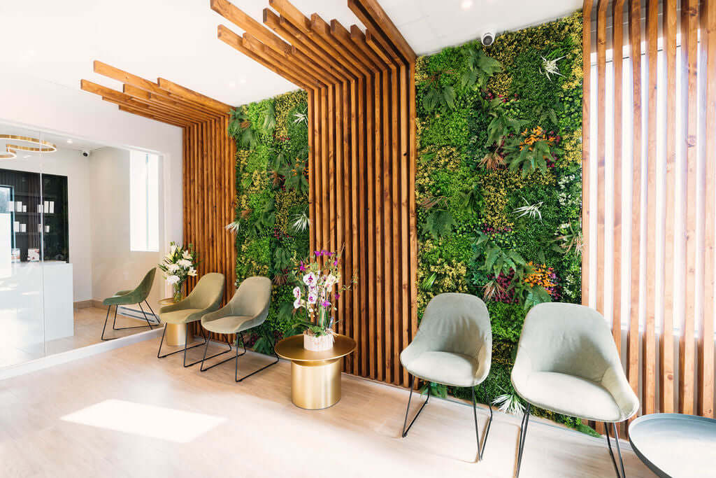 Salle d’attente chaleureuse à la clinique Unica MD à Montréal avec mur végétal et mobilier design